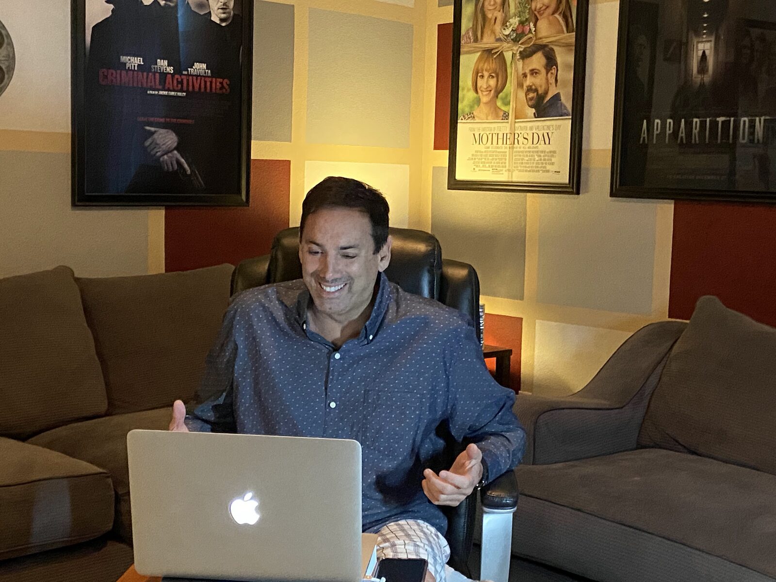 Howard Burd on a video consulting call in his office beneath his film posters